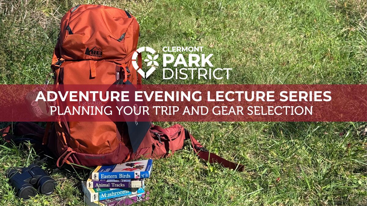 orange backpack in the grass with field guides and binoculars next to it